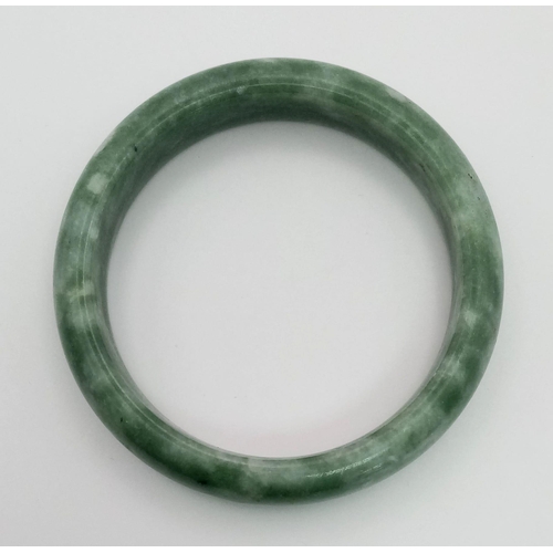 437 - A Pale Green and White Jade Bangle. Inner diameter 6cm.