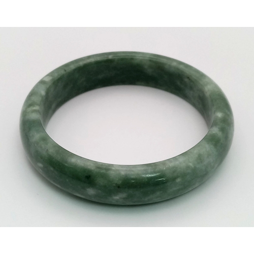 437 - A Pale Green and White Jade Bangle. Inner diameter 6cm.