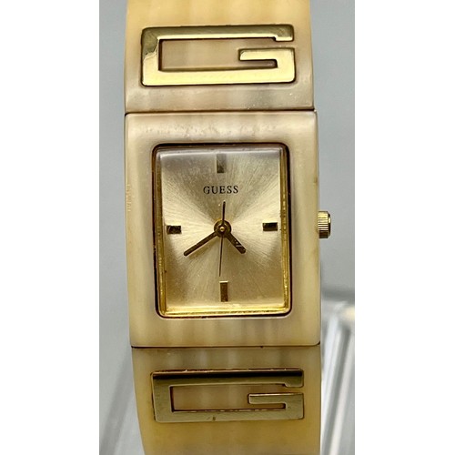 492 - A Guess Ladies Gilt and Ceramic Quartz Dress Watch. In working order.