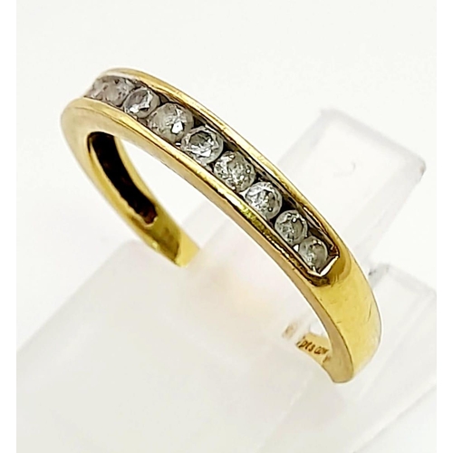 822 - AN 18K GOLD HALF ETERNITY RING WITH .25CT CHANNEL SET DIAMONDS.  2.1gms  size K