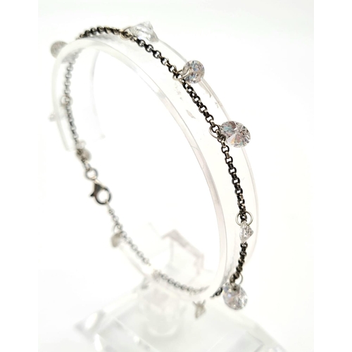 617 - A SILVER CRYSTAL CHARM BRACELET.   5.2gms