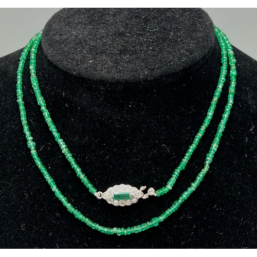 338 - A Natural Emerald and Diamond Necklace. Small emerald beads with an emerald and 12 diamond clasp on ... 