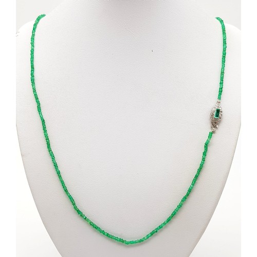 338 - A Natural Emerald and Diamond Necklace. Small emerald beads with an emerald and 12 diamond clasp on ... 