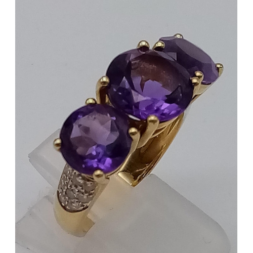 469 - An 18K Yellow Gold and Large Three-Stone Amethyst and Diamond Ring. Three central intense clean amet... 