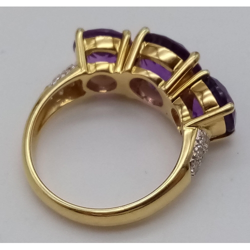 469 - An 18K Yellow Gold and Large Three-Stone Amethyst and Diamond Ring. Three central intense clean amet... 