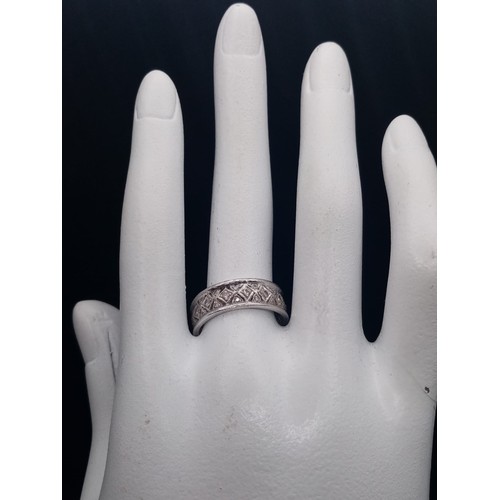 551 - An 18K White Gold Geometric Patterned Diamond Eternity Ring. Size O. 5.6g.