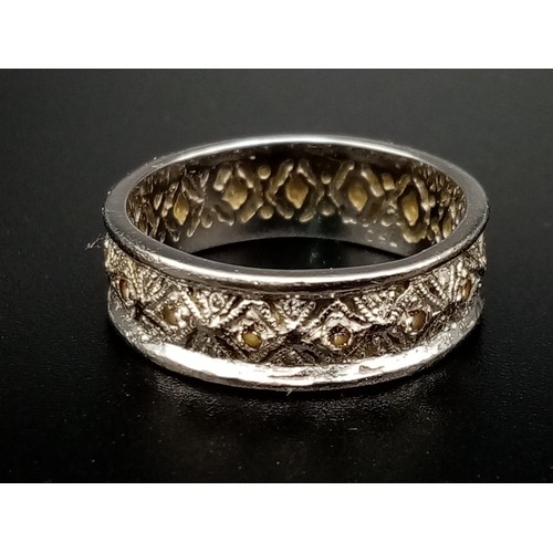 551 - An 18K White Gold Geometric Patterned Diamond Eternity Ring. Size O. 5.6g.