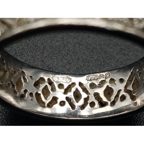 551 - An 18K White Gold Geometric Patterned Diamond Eternity Ring. Size O. 5.6g.