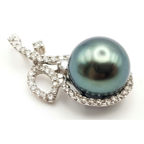 533 - AN 18K WHITE GOLD PENDANT WITH A BLACK SOUTH SEA PEARL AND DIAMOND ENCRUSTING.  3.3gms  2.5cms