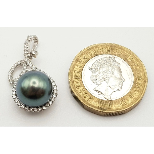 533 - AN 18K WHITE GOLD PENDANT WITH A BLACK SOUTH SEA PEARL AND DIAMOND ENCRUSTING.  3.3gms  2.5cms