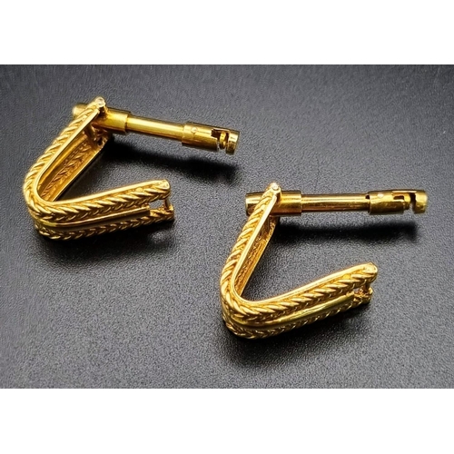 64 - A Vintage Pair of 18K Yellow Gold Kutchinsky Stirrup Cufflinks. Scrolled rope twist borders framing ... 