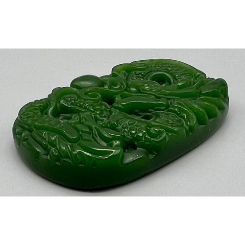 441 - A Carved Dragon Decorated Green Jade Pendant. 3.5 x 5cm.