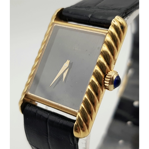 598 - An 18 K yellow gold, ladies, BAUME & MERCIER watch. 20 mm dial, black face with gold hands, sapphire... 