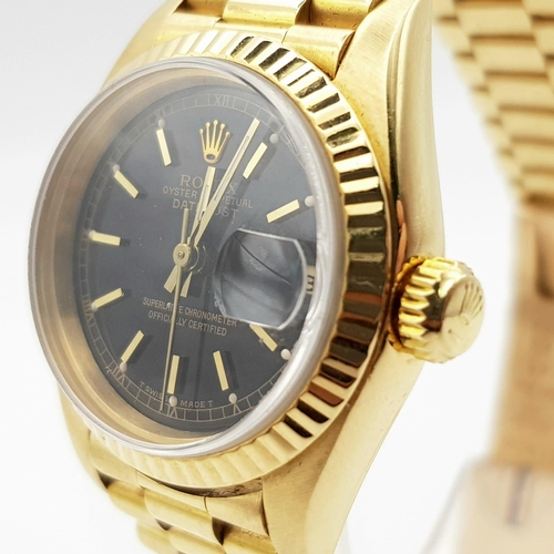 667 - An 18 k yellow gold, ladies, ROLEX DATEJUST watch. 26 mm dial, black face with gold hands and hour m... 