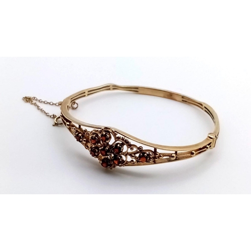 557 - A Victorian 9K Yellow Gold Bracelet with a Garnet Gemstone Floral Design. 6.5cm inner diameter. 13.2... 