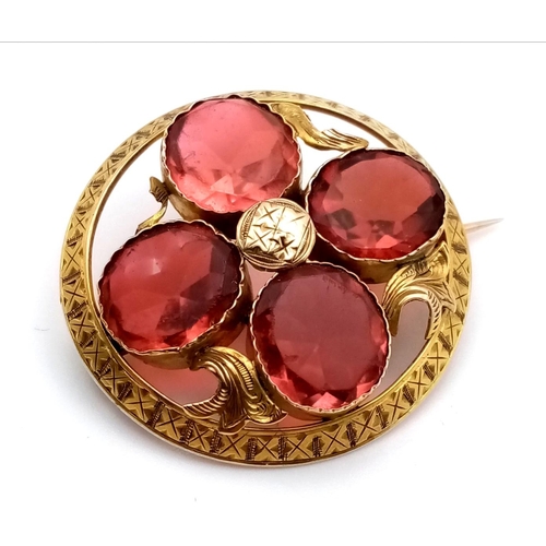 991 - An Early Yellow Metal Red Gemstone Circular Brooch. 3.5cm diameter. 8.2g total weight.