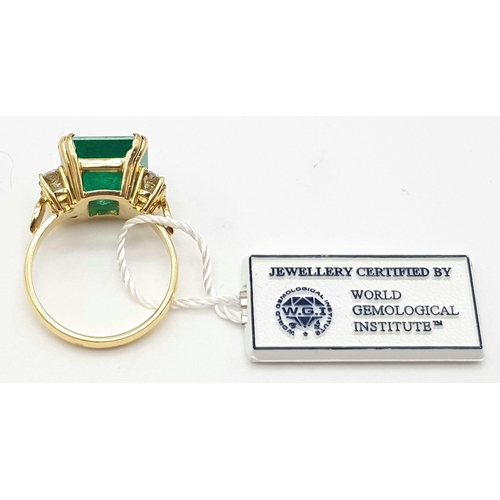 138 - A statement 18 K yellow gold ring with a Colombian emerald (7.96 carats) surrounded by four brillian... 