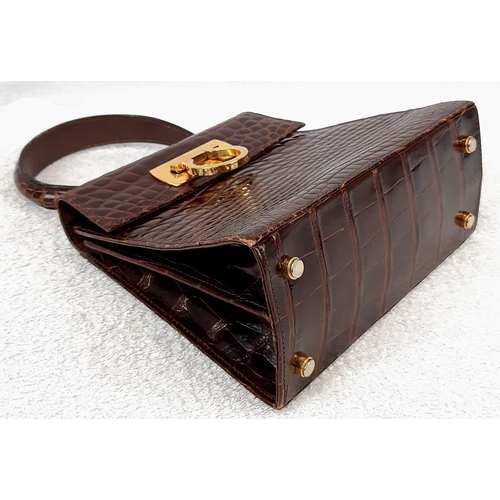 257 - An Italian Salvatore Ferragamo Crocodile Bag. Finished in chocolate brown with gilded touches and a ... 