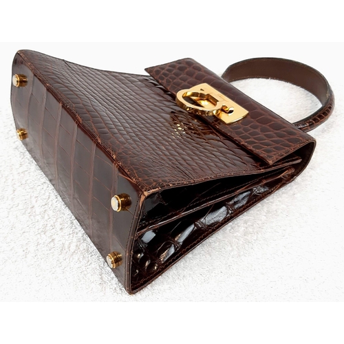 257 - An Italian Salvatore Ferragamo Crocodile Bag. Finished in chocolate brown with gilded touches and a ... 