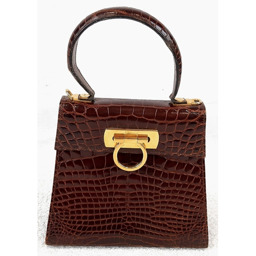 257 - An Italian Salvatore Ferragamo Crocodile Bag. Finished in chocolate brown with gilded touches and a ... 