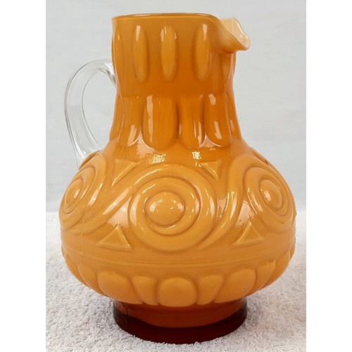 1141 - AN EARLY ITALIAN PATTERNED GLASS JUG IN AN UNUSUAL MUSTARD COLOUR.   22cms tall