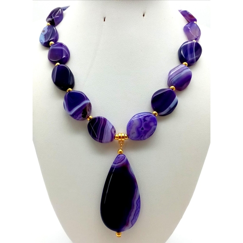 147 - A glamorous, large beaded, banded, purple agate, necklace and earrings set. Necklace length: 50 cm, ... 