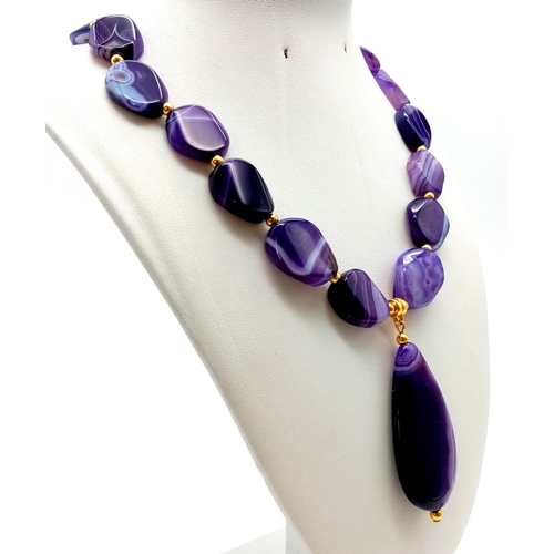 147 - A glamorous, large beaded, banded, purple agate, necklace and earrings set. Necklace length: 50 cm, ... 