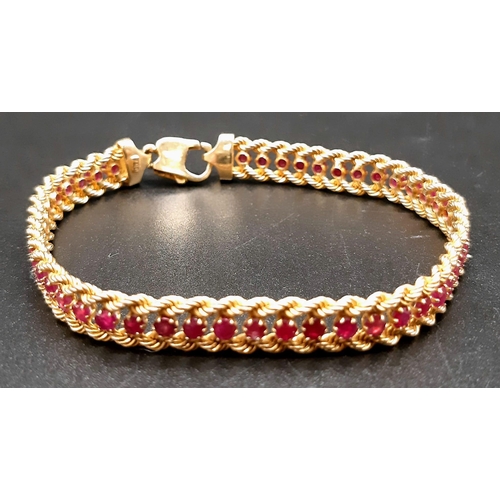 2 - An 18k Yellow Gold and Ruby Tennis Bracelet. Rope links either sider of 47 rubies. 17cm. 14.89g tota... 