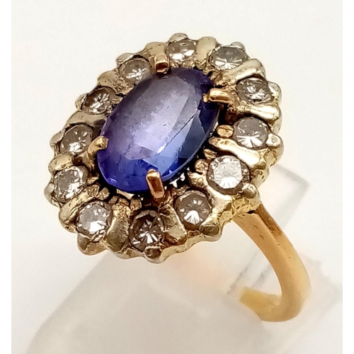 120 - A vintage gold ring with a central oval cut amethyst surrounded by a halo of rose cut diamonds. Ring... 