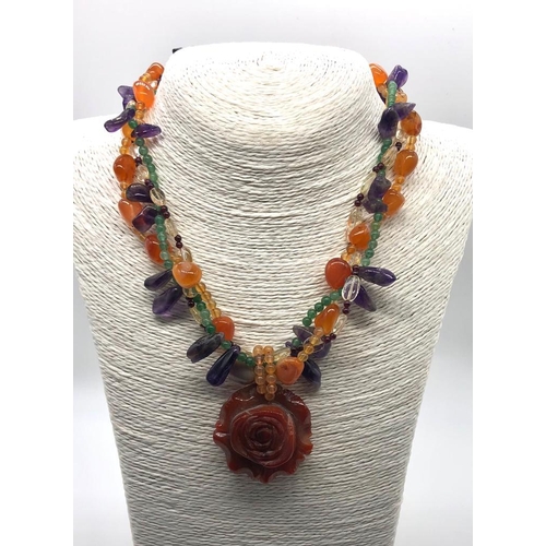 305 - A Natural Carved Carnelian Amethyst and Garnet Necklace. Large carnelian central flower with three r... 