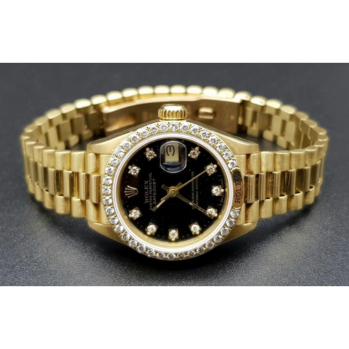 66 - An 18 K yellow gold ladies ROLEX DATEJUST watch. 26 mm dial, black face with diamonds on hour marks ... 