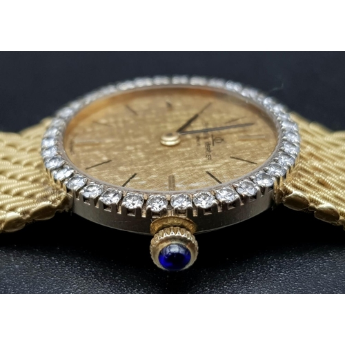 163 - An 18 K yellow gold BAUME & MERCIER ladies watch. 24 mm dial with gold face, bezel with diamonds and... 