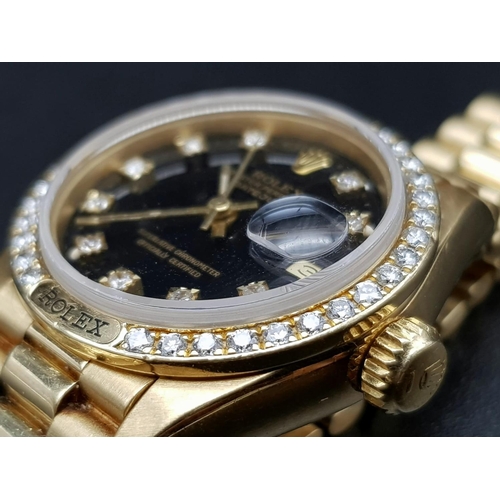 66 - An 18 K yellow gold ladies ROLEX DATEJUST watch. 26 mm dial, black face with diamonds on hour marks ... 