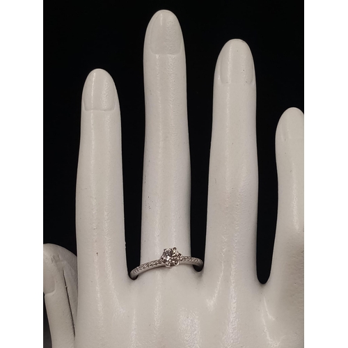 696 - A 9K White Gold Diamond Ring. Central diamond with diamonds on shoulders. 0.35 and 0.20ct. Size O.
1... 