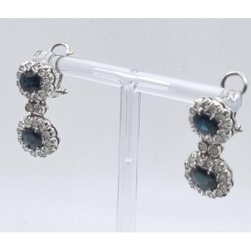 358 - An 18 K white gold pair of earrings with diamonds and blue/green sapphires. Length: 25 mm, total wei... 