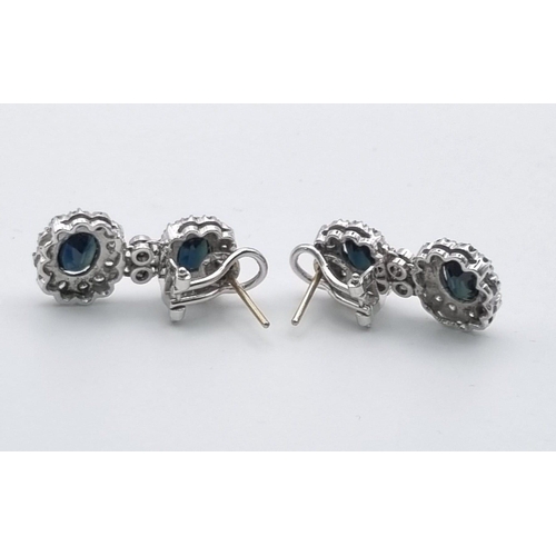 358 - An 18 K white gold pair of earrings with diamonds and blue/green sapphires. Length: 25 mm, total wei... 