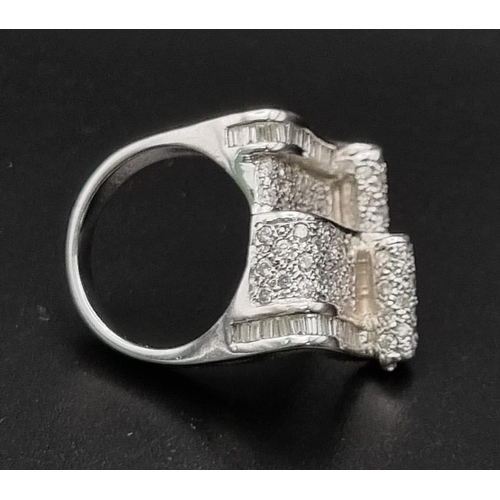 88 - An 18 K white gold ring with two scrolls loaded with baguette and brilliant cut diamonds. Ring size:... 