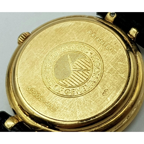 71 - An 18 K yellow gold SARCAR MAGIC MOON ladies watch. 25 mm dial, MOP face with windows to see part of... 