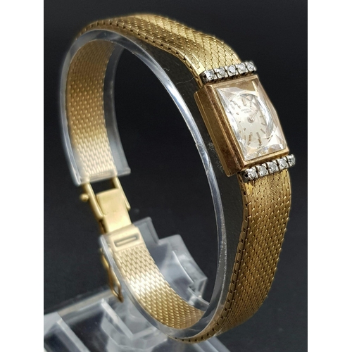 184 - A vintage 18 K yellow gold UNIVERSAL ladies watch. Rectangular dial (20 x 12 mm) with diamonds on th... 