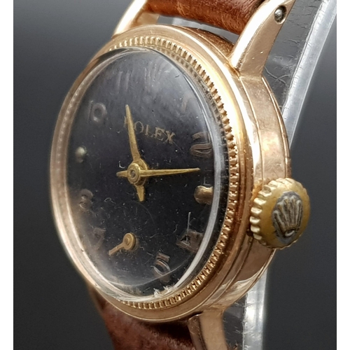 279 - A vintage rose gold ROLEX ladies watch. 20 mm dial, black face with rose gold hands and numerals. Ma... 