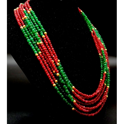 198 - A glamorous, seven row necklace of rubies and emeralds. Length: 47-55 cm, weight: 82 g.