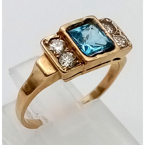 269 - An 18K Yellow Gold Topaz and Diamond Ring. Central square cut topaz with two diamonds either side. T... 