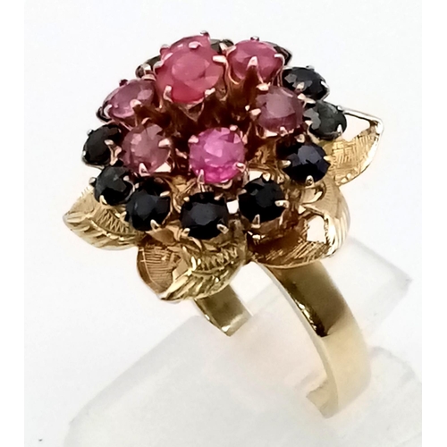 319 - A Vintage 18K Ruby and Sapphire Cluster Ring. Six central rubies with a halo of twelve sapphires. Si... 