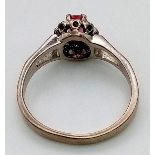 87 - A Vintage 18K White Gold Natural Burmese Ruby and Diamond Ring. Central ruby surrounded with a halo ... 