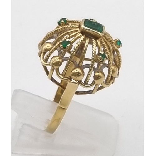 202 - A Vintage 18K Yellow Gold Dome-Shaped Emerald Ring. Central emerald with a further five smaller emer... 