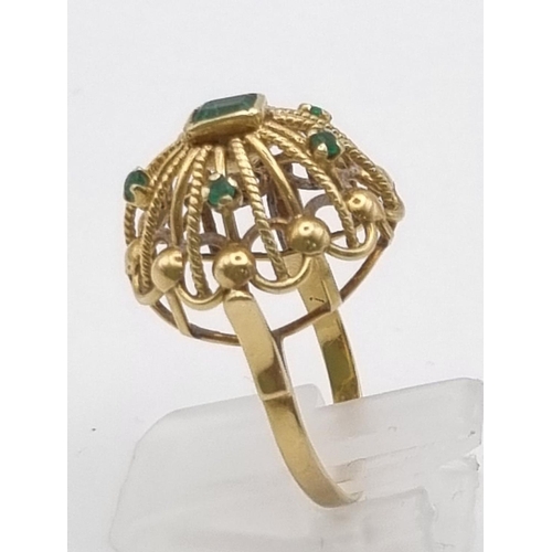 202 - A Vintage 18K Yellow Gold Dome-Shaped Emerald Ring. Central emerald with a further five smaller emer... 