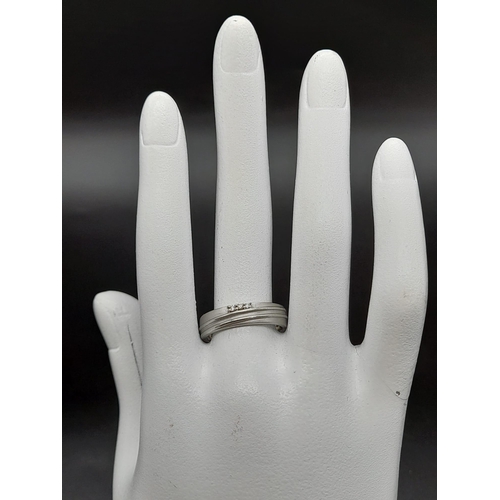 55 - A 950 Platinum Diamond Band Ring. Three small diamonds. Size Q. 5.19g total weight. Ref - 190