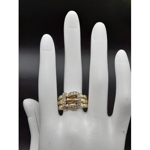 74 - A 9K Yellow Gold and Diamond Buckle Ring. 18 diamonds .25ct complement this keeper piece. Size Q. 9.... 