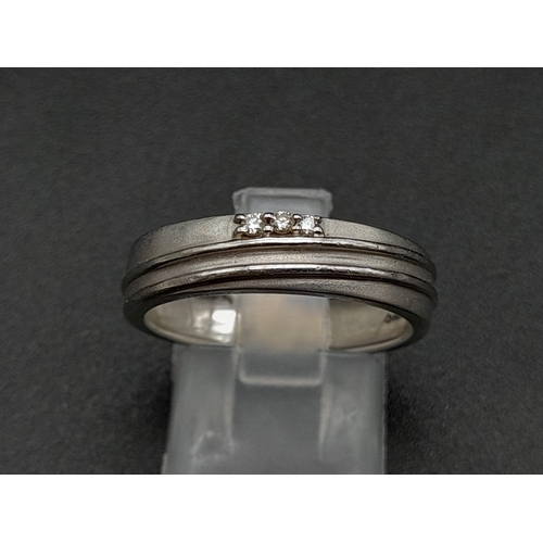 55 - A 950 Platinum Diamond Band Ring. Three small diamonds. Size Q. 5.19g total weight. Ref - 190