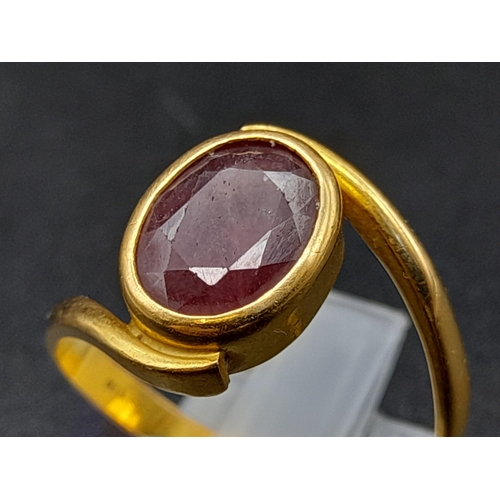 79 - A 22K Yellow Gold Red Stone Crossover Ring. Size Q. 4.87g total weight. A/F. Ref - 8667.